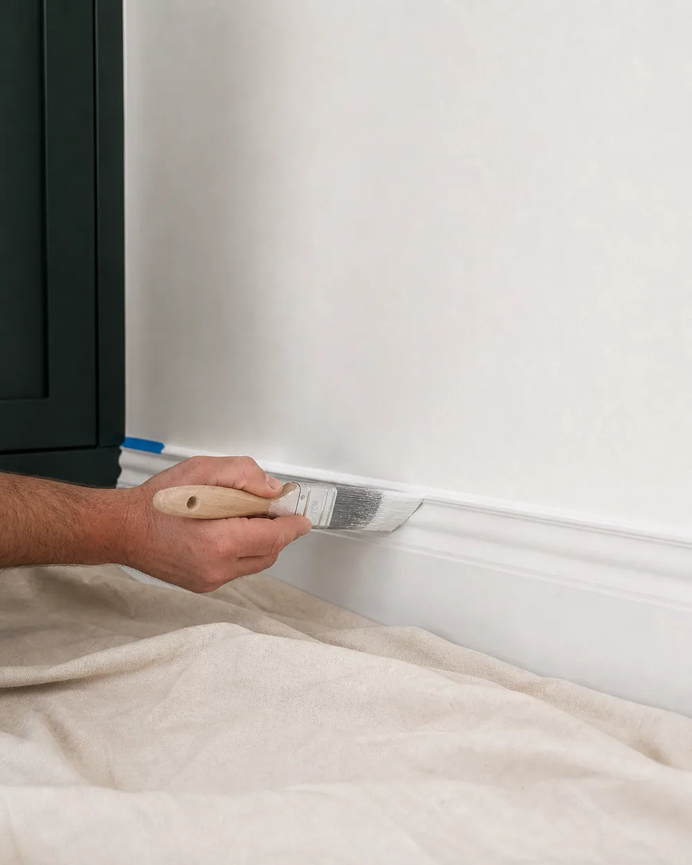 A professional hand applying a clean finish along traditional interior trim.